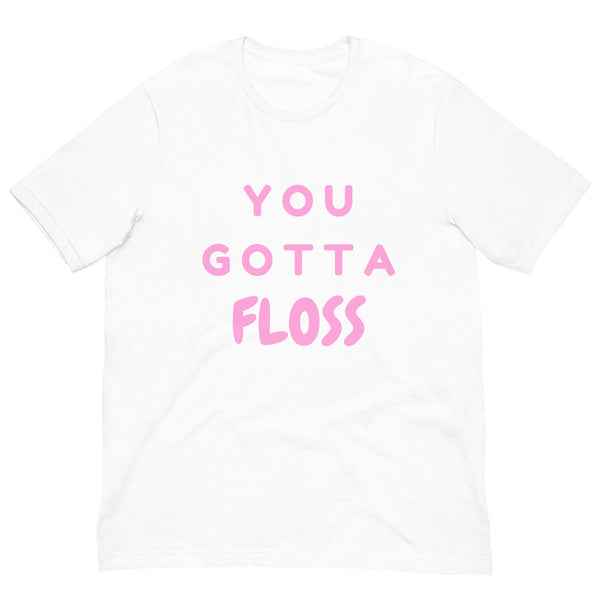 White T-shirt laid flat with pink lettering reading “YOU GOTTA FLOSS.”